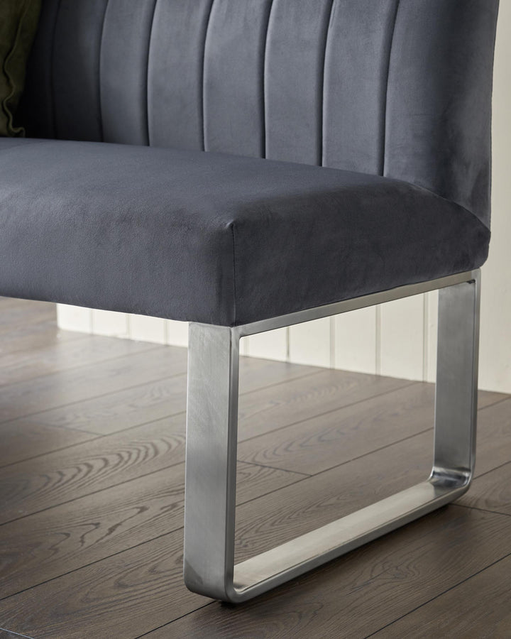 Close-up of a grey upholstered bench with a sleek, minimalist metal leg design, showcasing modern furniture craftsmanship.