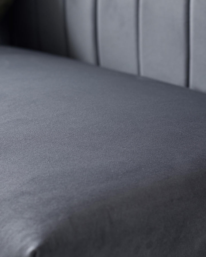 Close-up of a grey upholstered chair seat and back, showcasing the texture and design details.