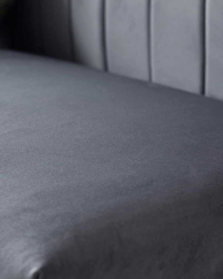 Close-up of a grey upholstered chair seat and back, showcasing the texture and design details.