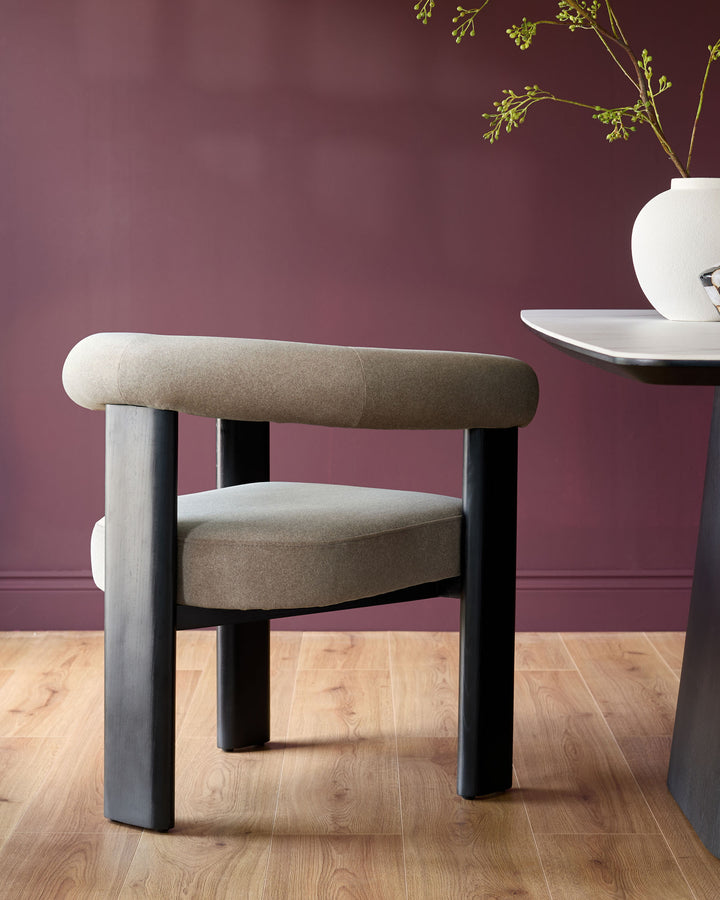 Stylish modern chair with padded seat and back, alongside a contemporary marble top table.