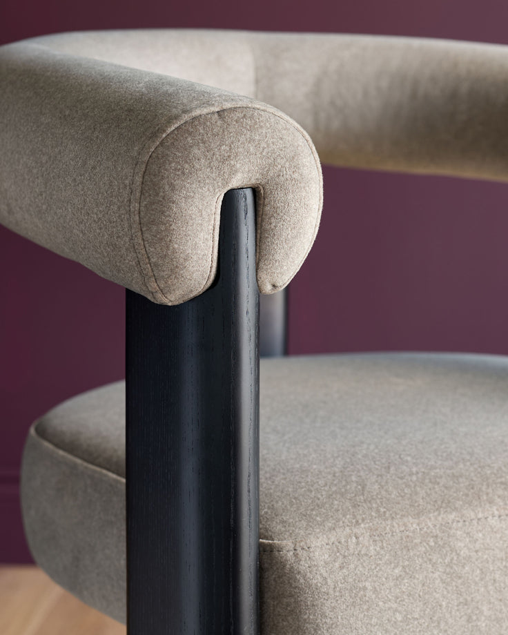 A stylish beige fabric chair with a dark wood frame. Ideal for modern living spaces.