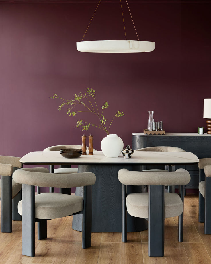 A modern dining set with a white marble-effect table, stylish grey chairs and a matching sideboard.