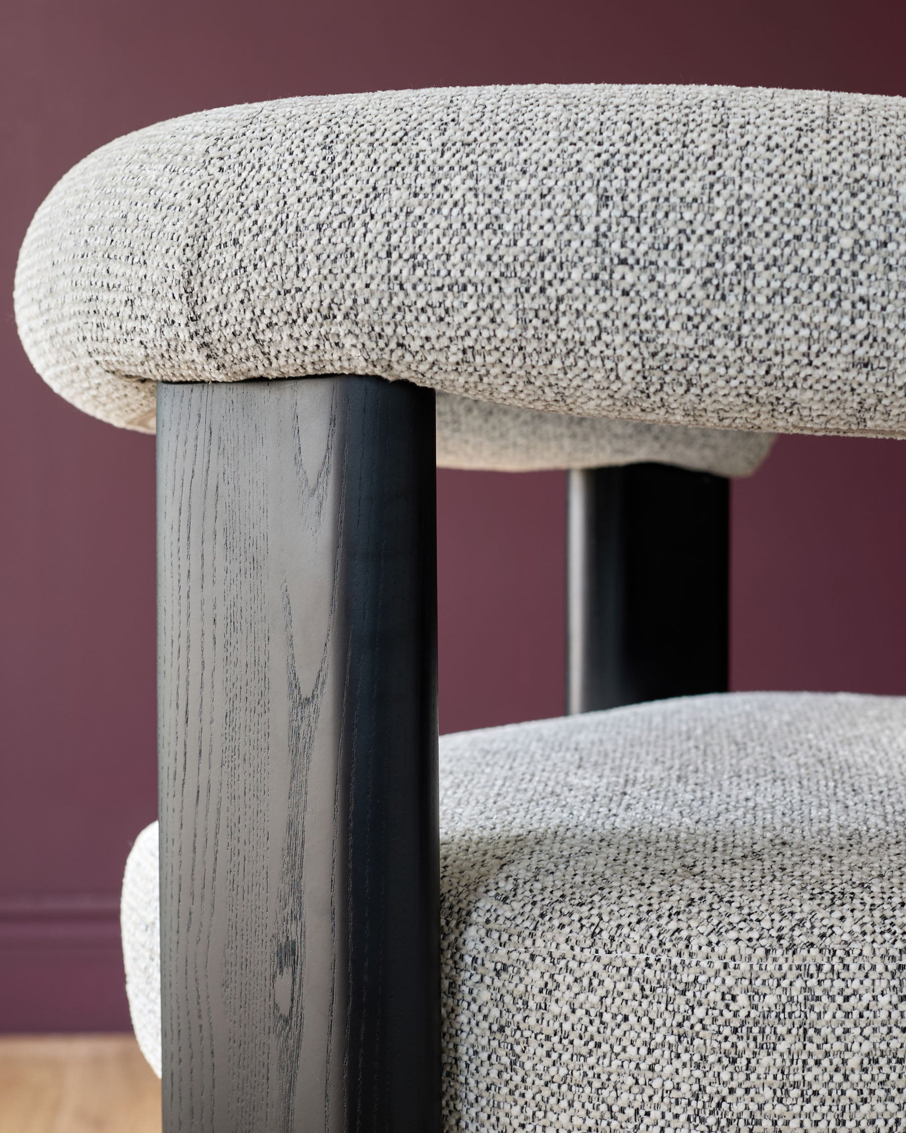 Close-up of a stylish chair featuring a woven fabric seat and back, complemented by dark wood legs. Modern furniture design.