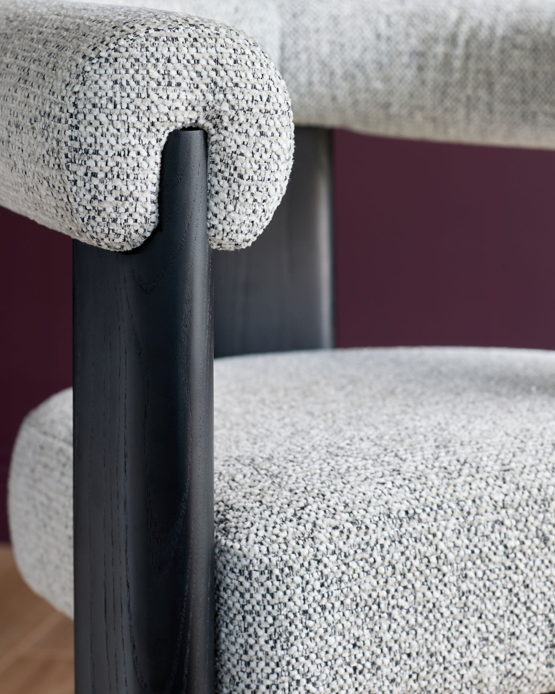 Stylish chair featuring a grey textured fabric seat and back, complemented by dark wooden armrests and frame.
