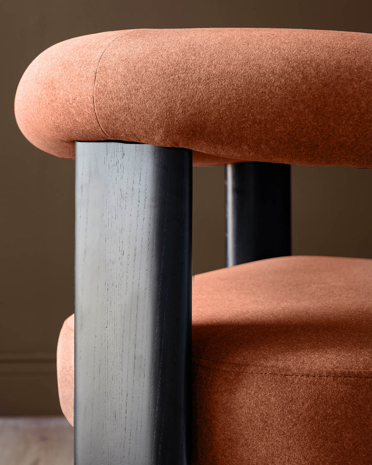 Orion dining chair in toffee fabric with curved backrest and black wooden legs, side detail view.