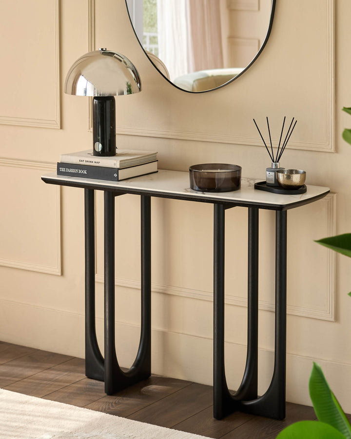 Stylish console table with a marble top and dark wood legs, adorned with elegant accessories. Perfect for a modern hallway.