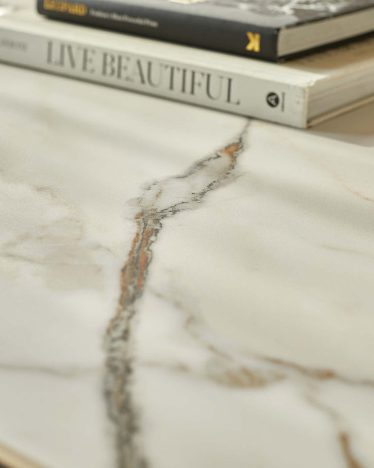 Close-up of a marble-effect table with books, showing the texture and design details.