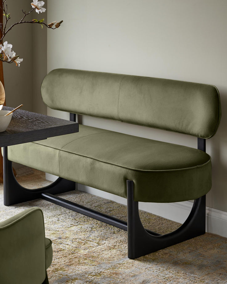 Orlan dining bench with backrest in olive green velvet, featuring black curved wooden legs and a cylindrical backrest pillow.