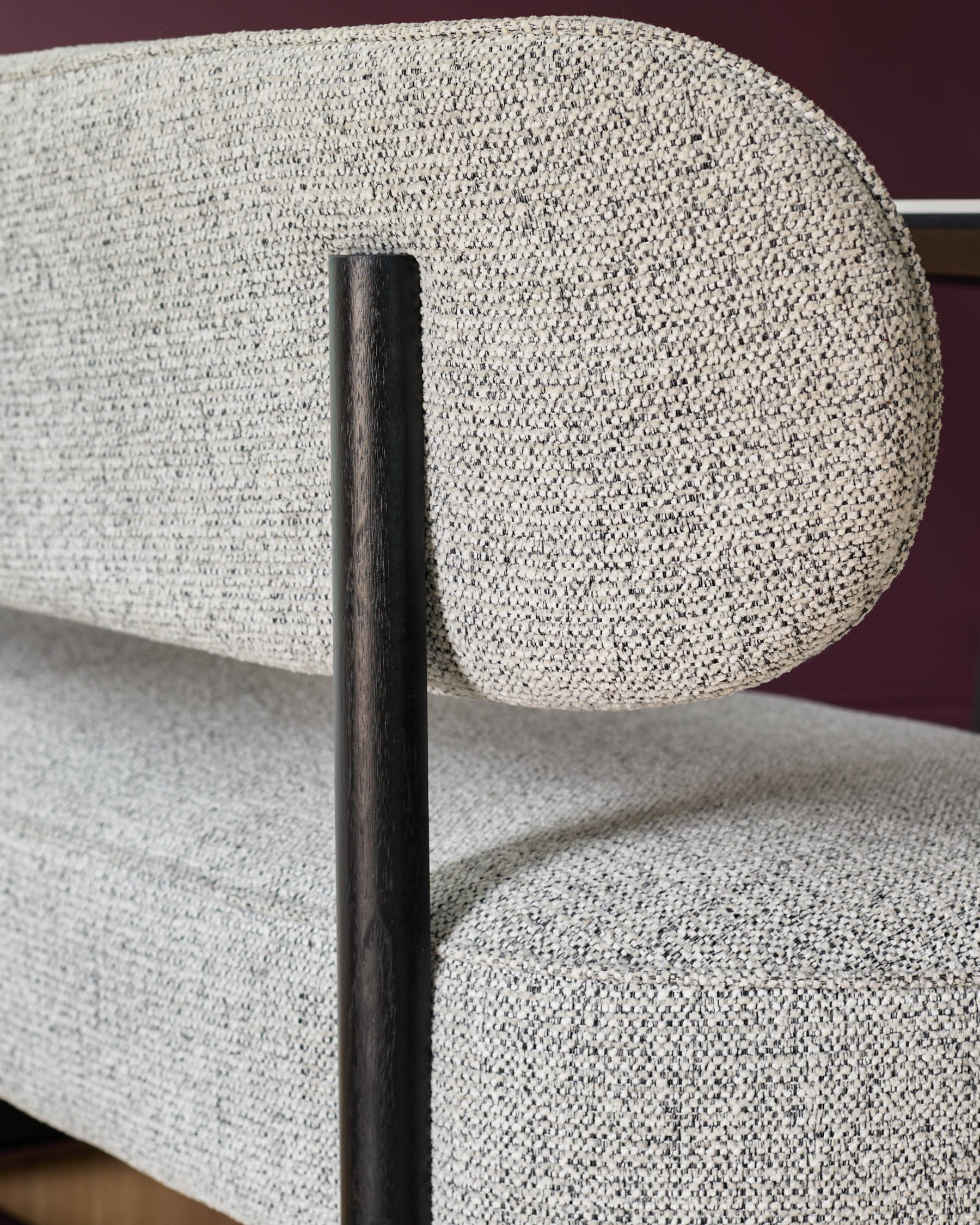 A stylish settee with a textured grey and white fabric, and a dark wood frame. Modern and comfortable.