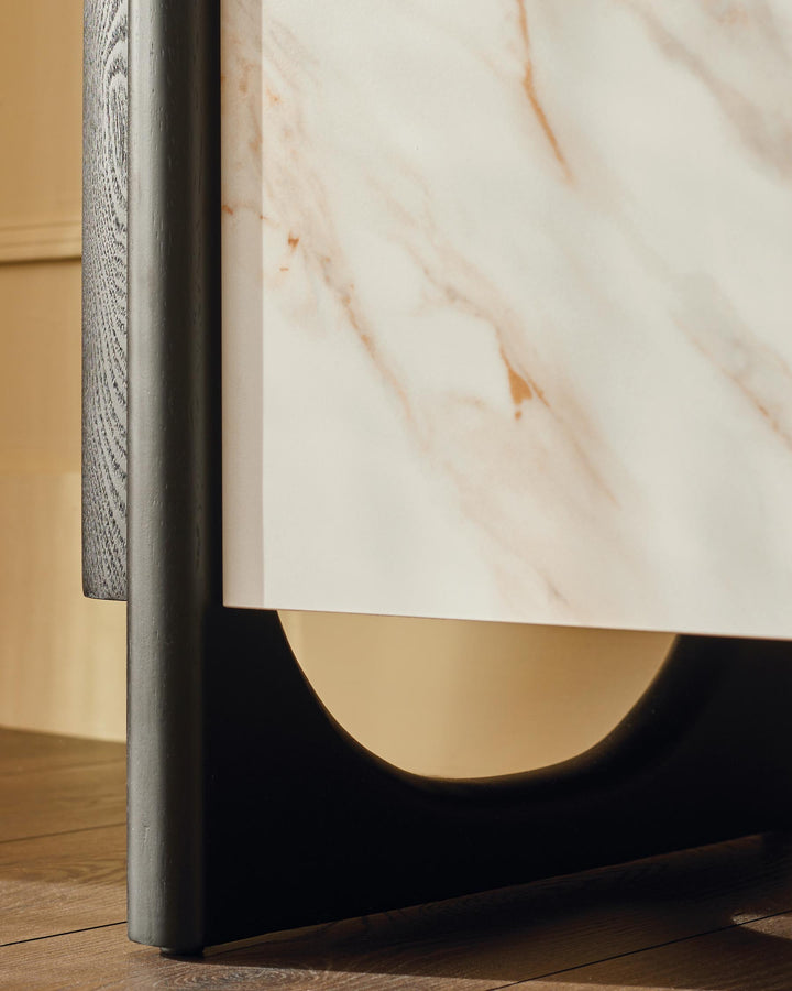 Close-up of elegant cabinet featuring marble top, wooden frame, and brass detailing, offering a modern, sophisticated look.