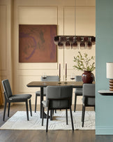 Otis dining chair in dark grey leather, shown in a modern dining room setting around a dark wood table.