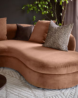 Ottilie right-hand corner chaise sofa in apricot fabric, styled with decorative pillows and trailing foliage plant.