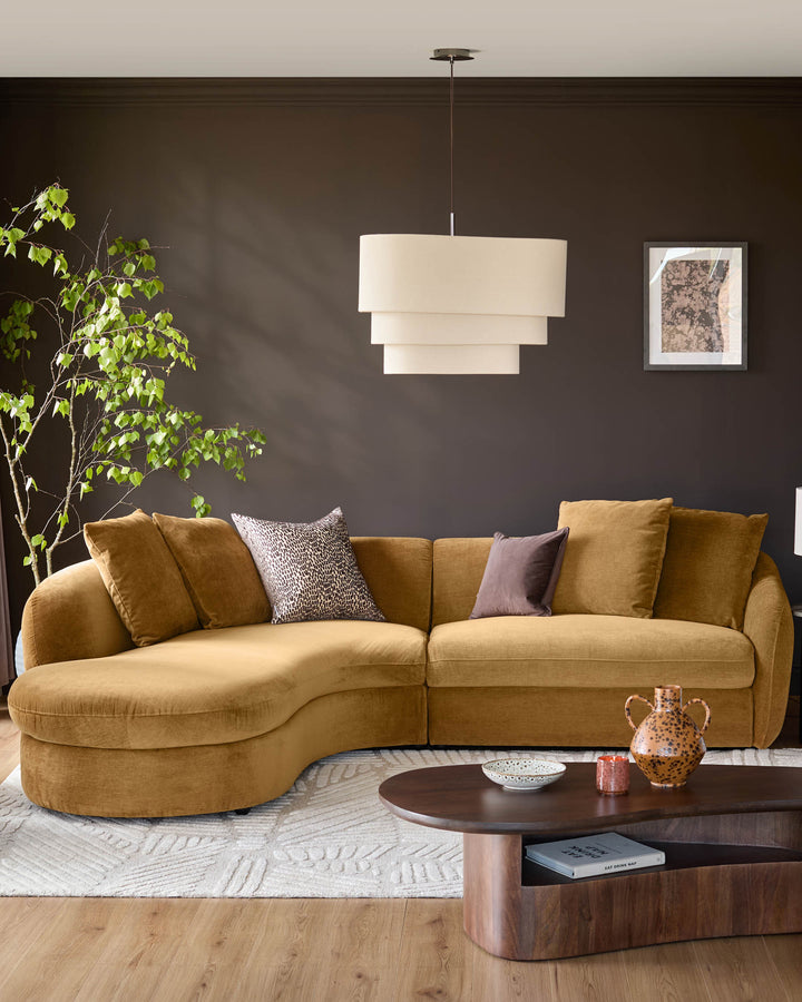 Ochre fabric left-hand corner chaise sofa with curved design and decorative pillows in a modern living room setting.