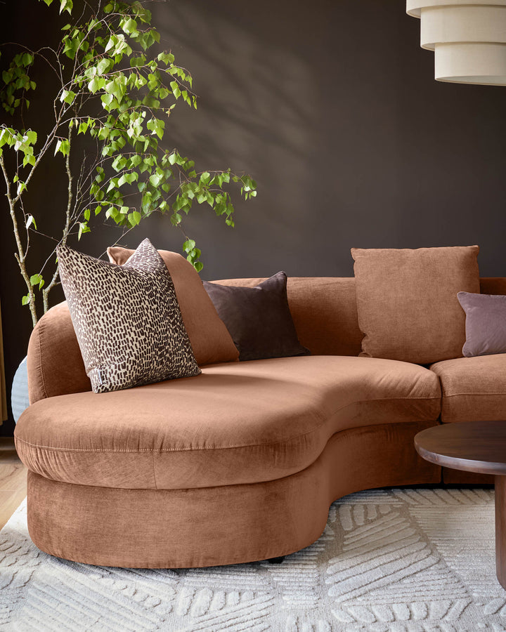 Ottilie left-hand corner chaise sofa in apricot fabric, styled with decorative pillows in a modern living room setting.