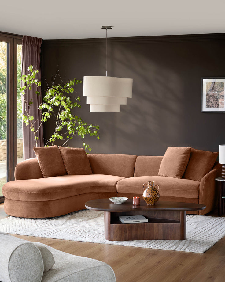 Ottilie left-hand corner chaise sofa in apricot fabric, shown in a modern living room setting with dark walls.