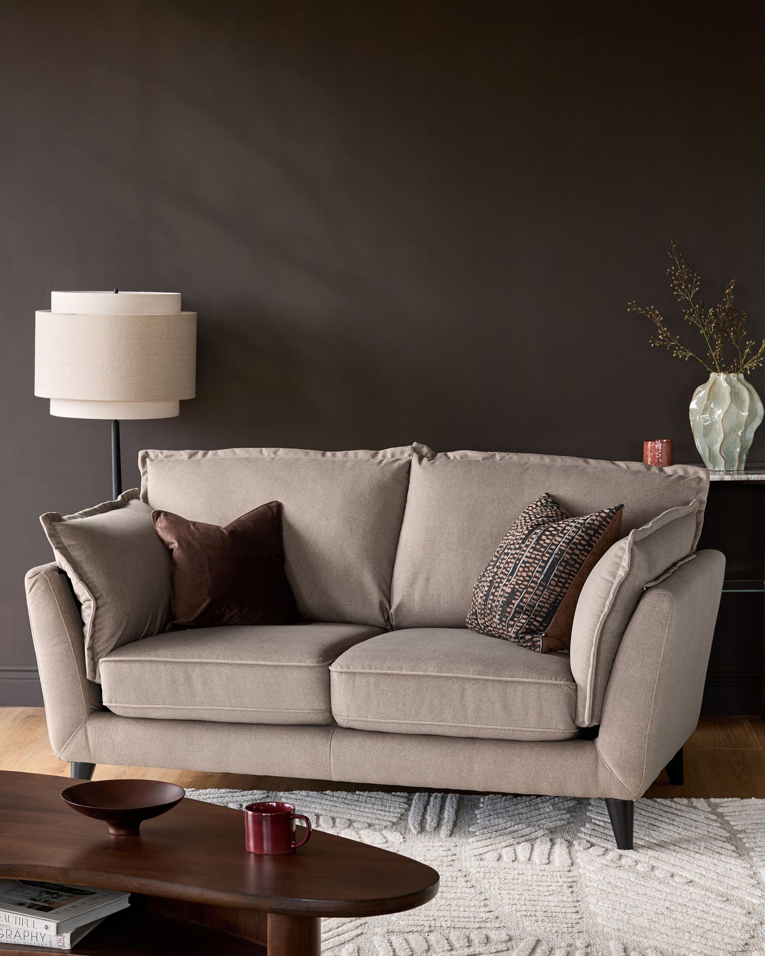 Otto 2-seater sofa in mocha fabric, shown in a styled living room setting with decorative pillows and neutral décor.