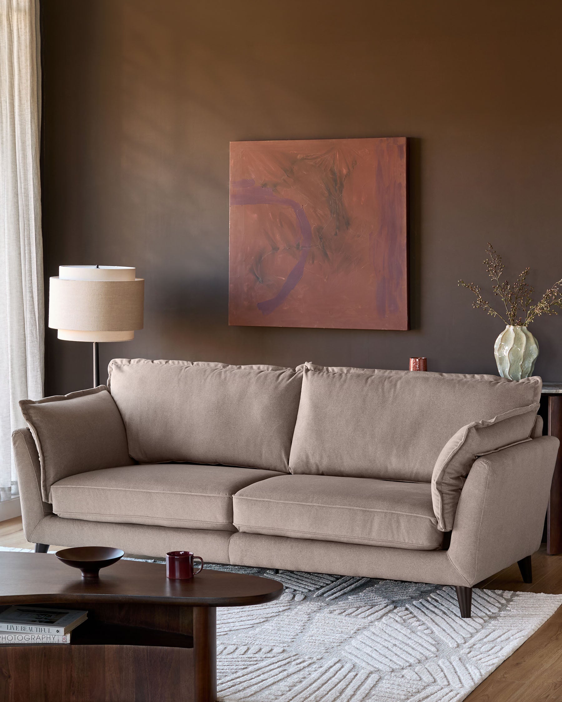 Otto 3-seater sofa in mocha fabric, displayed in a styled living room setting with neutral decor and warm lighting.