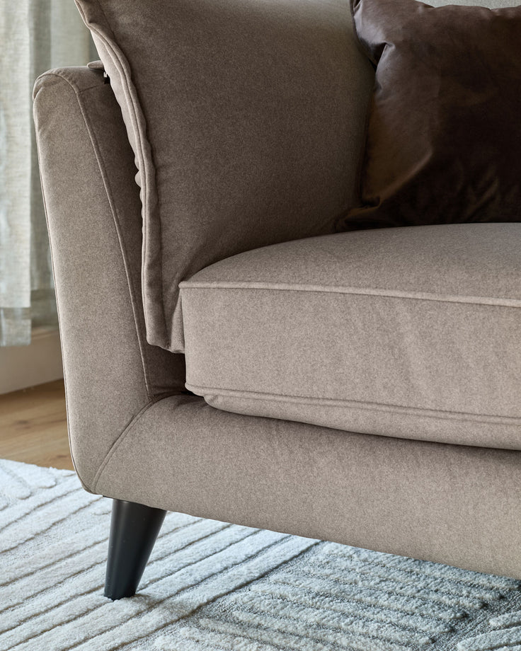 Otto 3-seater sofa in mocha fabric, side view showing cushioned seat, back pillow, and dark tapered legs on striped rug.