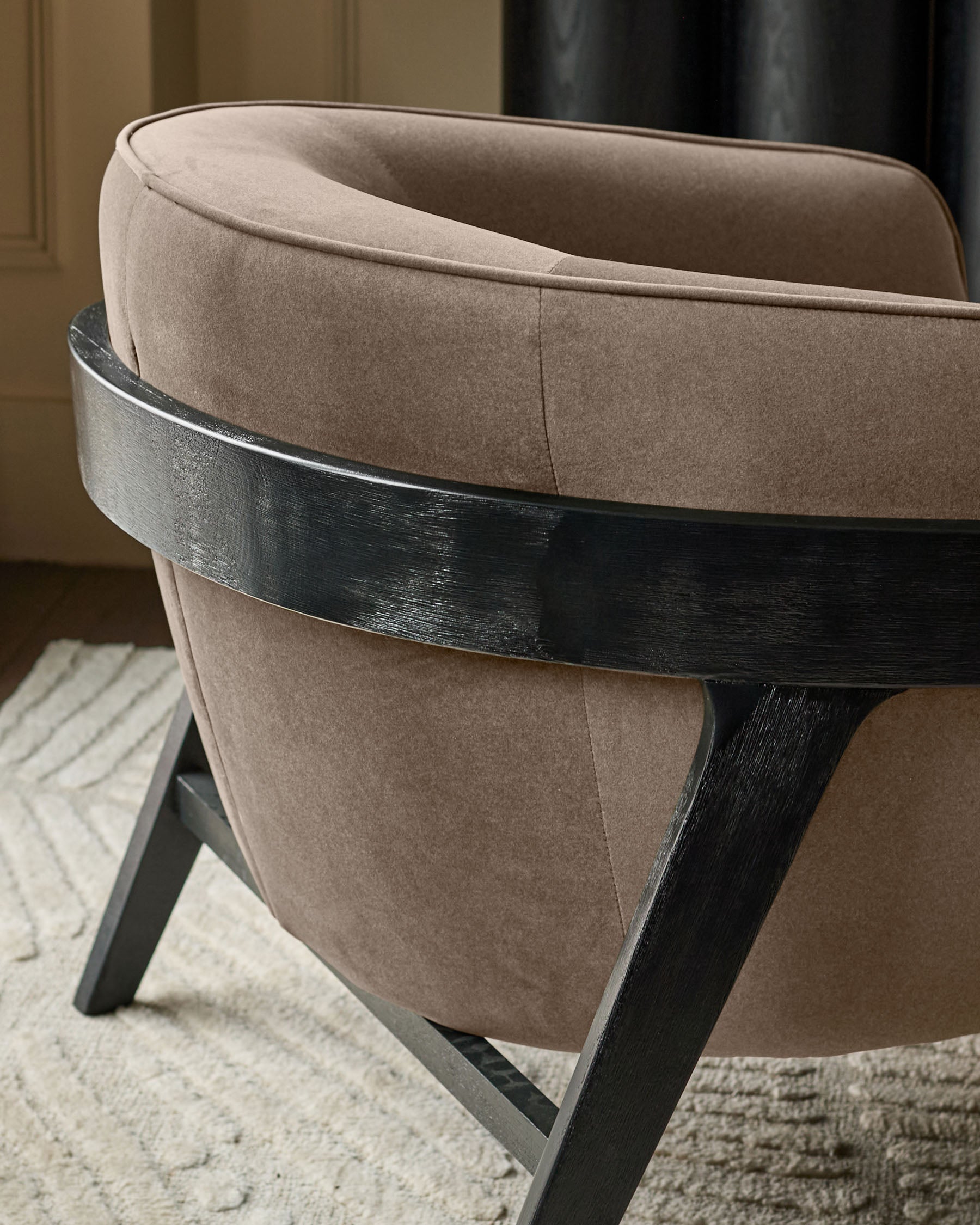 Palmer occasional chair in mocha fabric with black wooden frame, shown from rear three-quarter view on cream area rug.