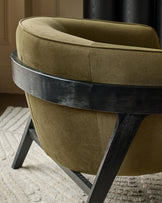 Palmer occasional chair in pistachio green fabric with black wood frame, shown from rear angle on neutral rug.