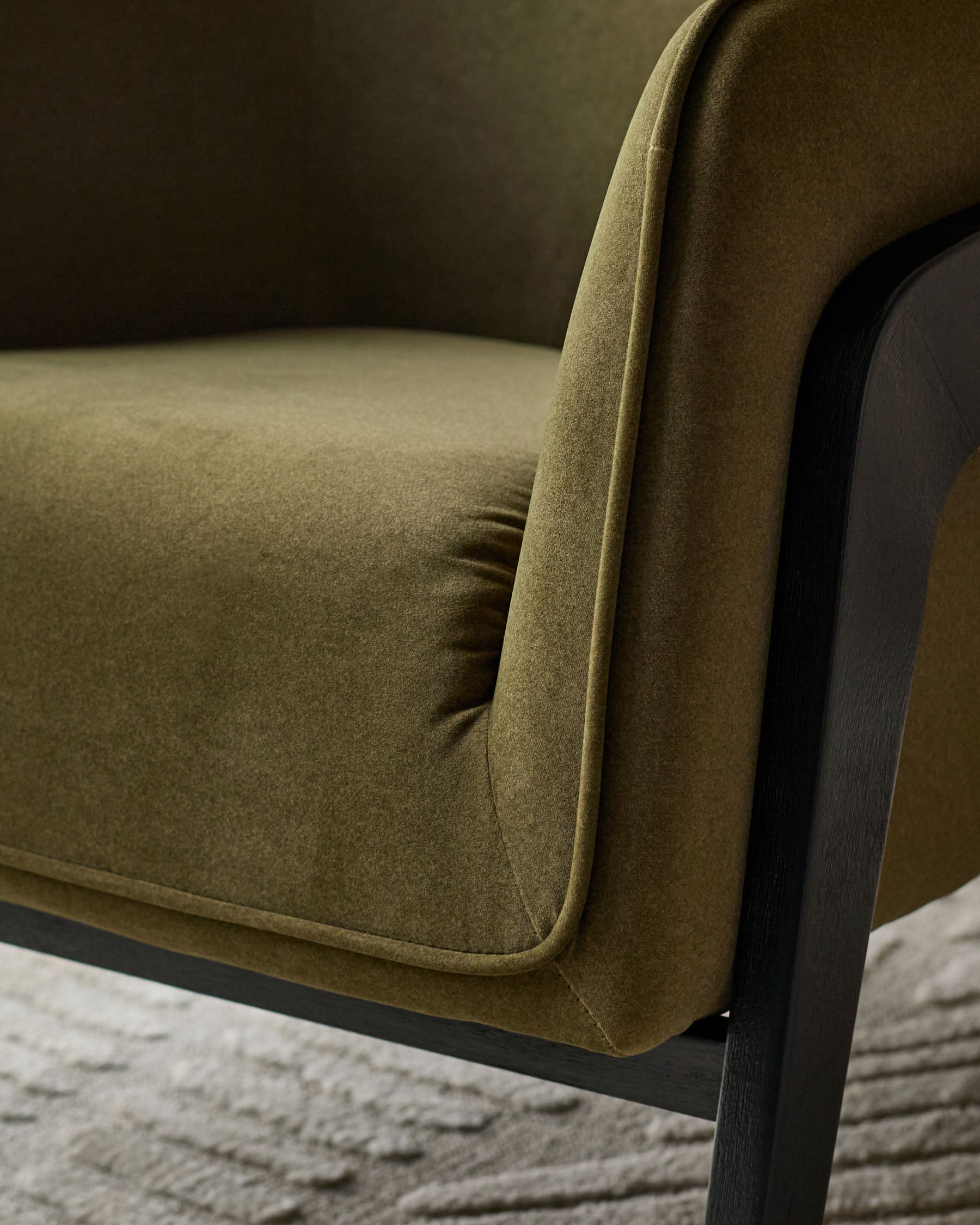 Palmer Occasional Chair in pistachio green fabric with curved backrest and dark wooden frame, side view detail.
