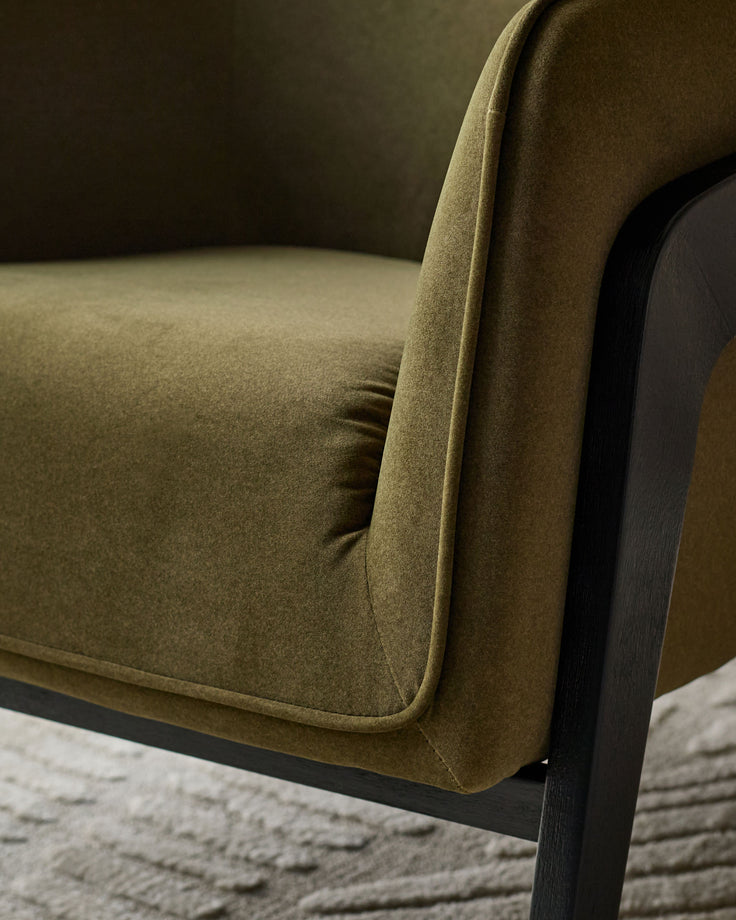 Palmer Occasional Chair in pistachio green fabric with curved backrest and dark wooden frame, side view detail.