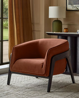 Palmer Occasional Chair in toffee-red fabric with black wooden legs, shown in a styled living room setting.