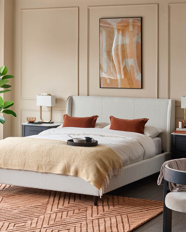 Bedroom with upholstered bed, bedside tables, a rug and a statement artwork.