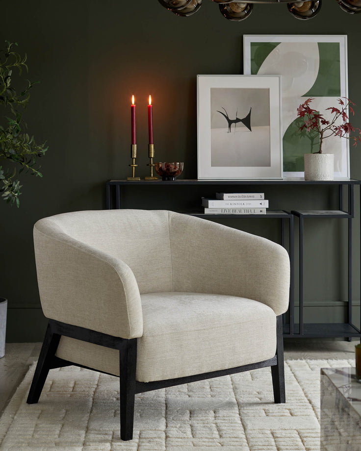 A contemporary armchair with a neutral fabric and dark wood frame sits on a textured rug in a stylish living room.