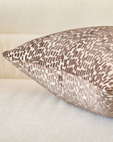 Payton cushion in chocolate, close-up detail showing textured woven pattern and piped edge on neutral background.