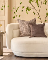 Payton Large Chocolate Cushion displayed on a cream armchair in a styled living room setting.