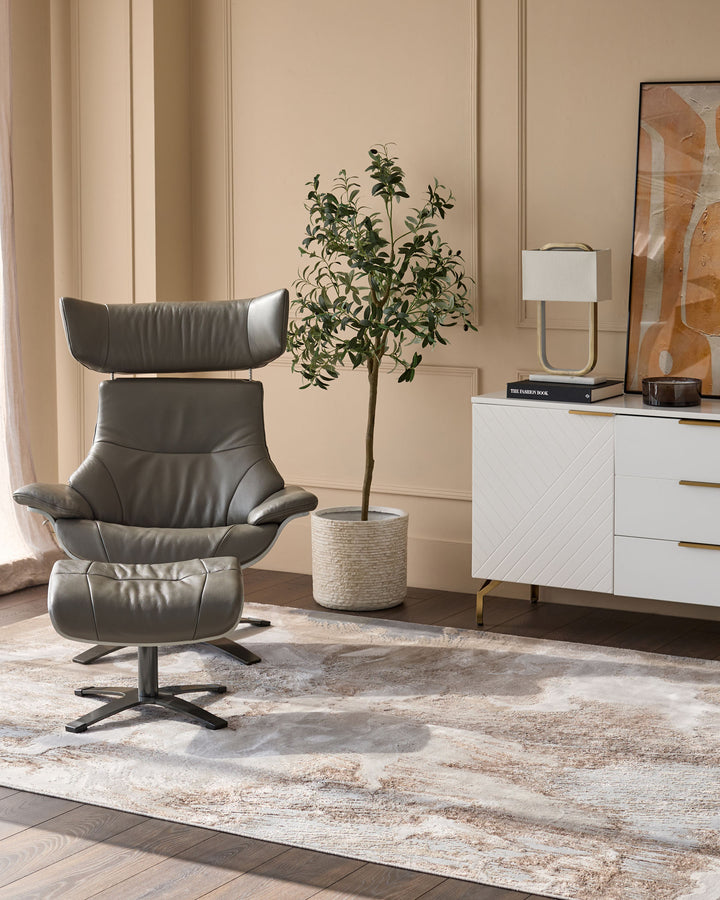 Perla Expression medium textured rug in silver, displayed in a modern living room setting with a Grey leather chair and white dresser.