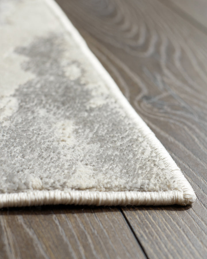 A close-up shot of a stylish rug with a neutral pattern, complemented by the natural tones of a wooden floor.