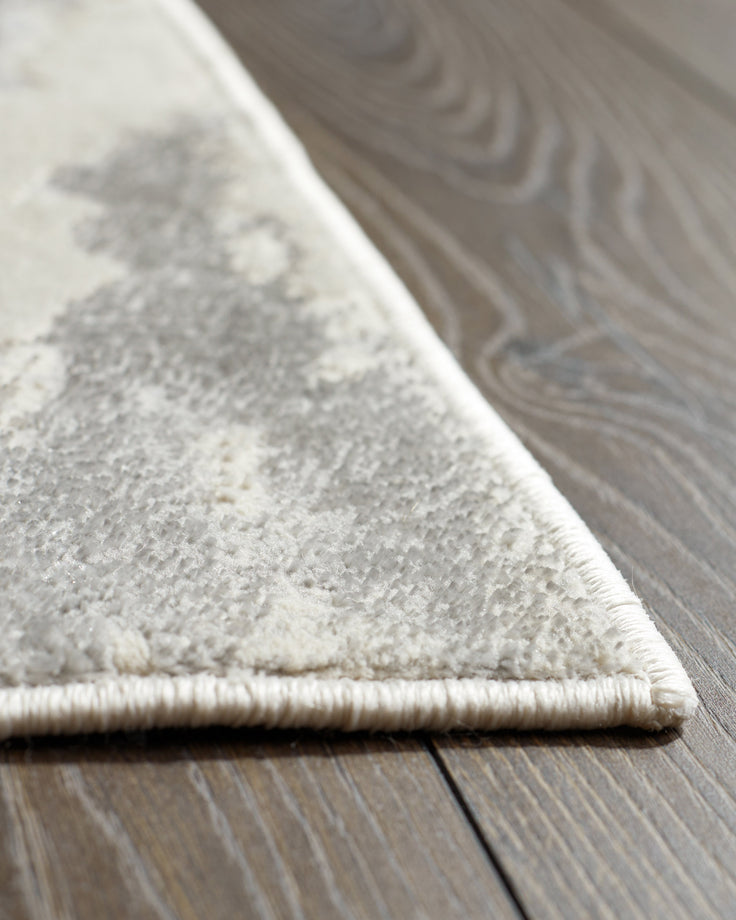 A close-up shot of a stylish rug with a neutral pattern, complemented by the natural tones of a wooden floor.