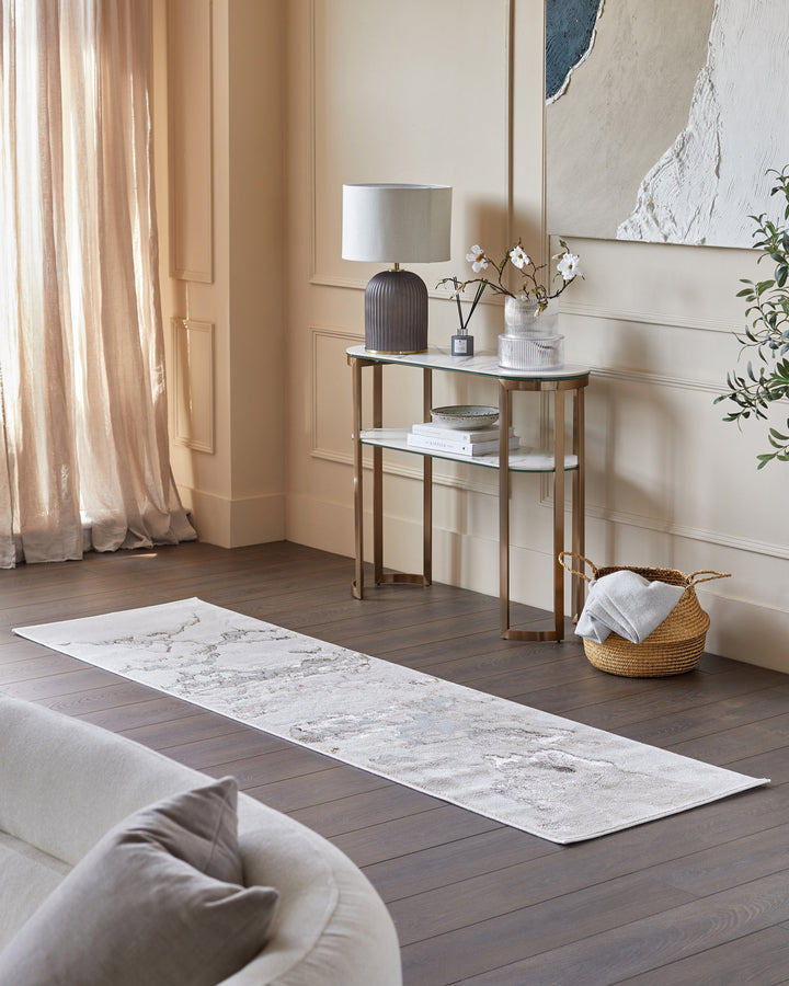 Elegant hallway with a marble-patterned runner, gold-framed console table, and soft furnishings for a stylish, inviting space.