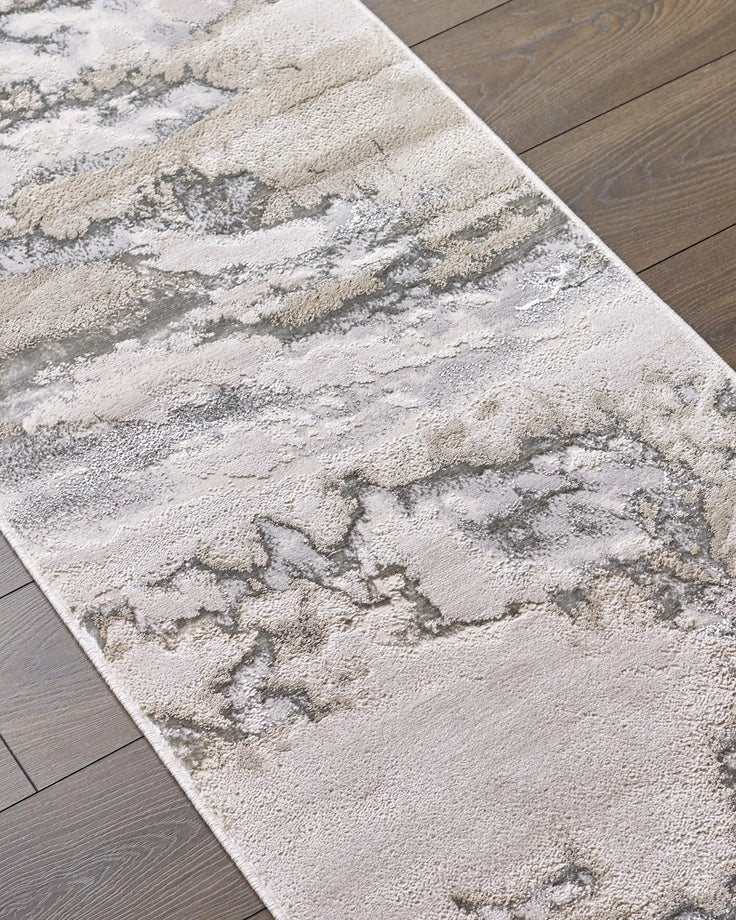 Perla runner rug in soft silver and cream tones with textured abstract pattern on wooden floor.