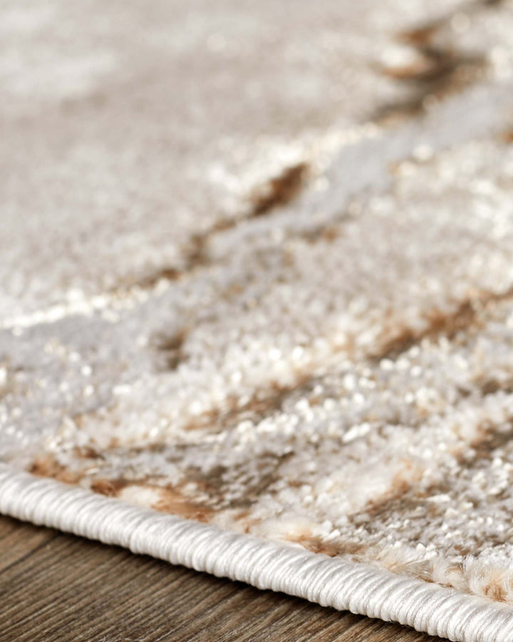 Perla Large Easy Living Textured Rug in soft metallics and gold, close-up detail shot showing woven texture and edge binding.
