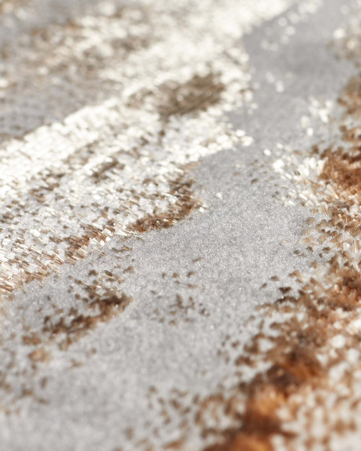 Close-up of Perla large rug showing soft metallics in gold and cream with textured woven surface detail.