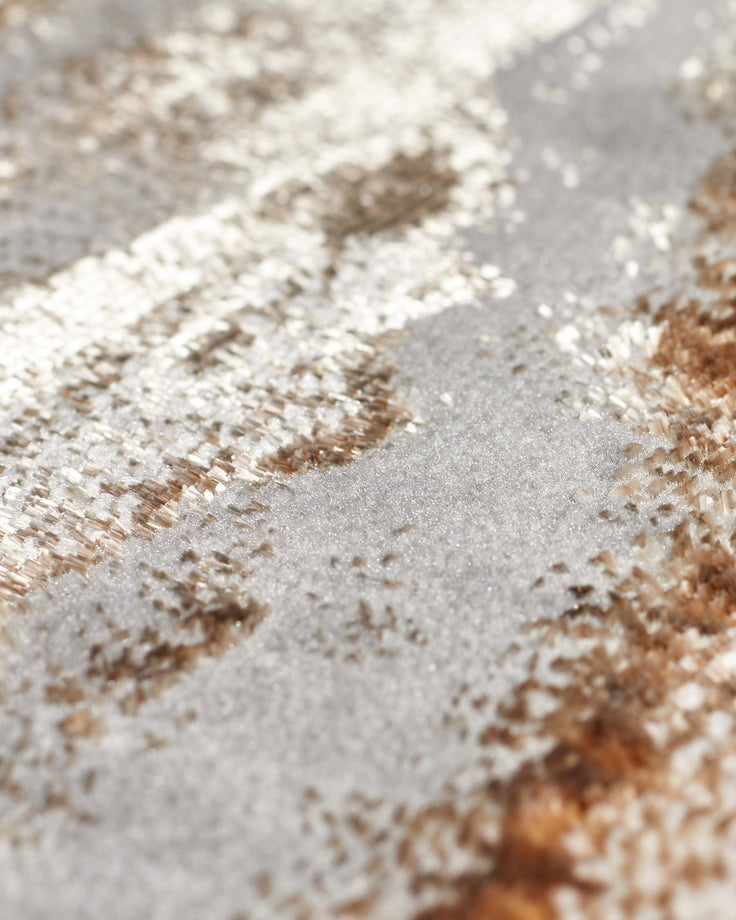 Close-up of Perla large rug showing soft metallics in gold and cream with textured woven surface detail.