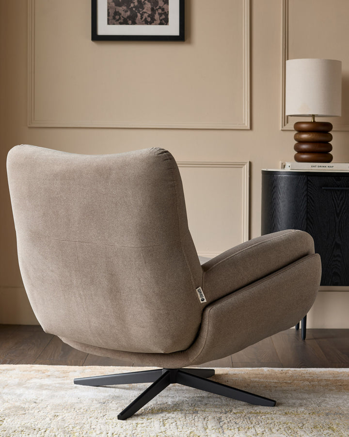 Mocha fabric accent chair with curved back, padded armrests, and black four-star base, shown from rear angle.