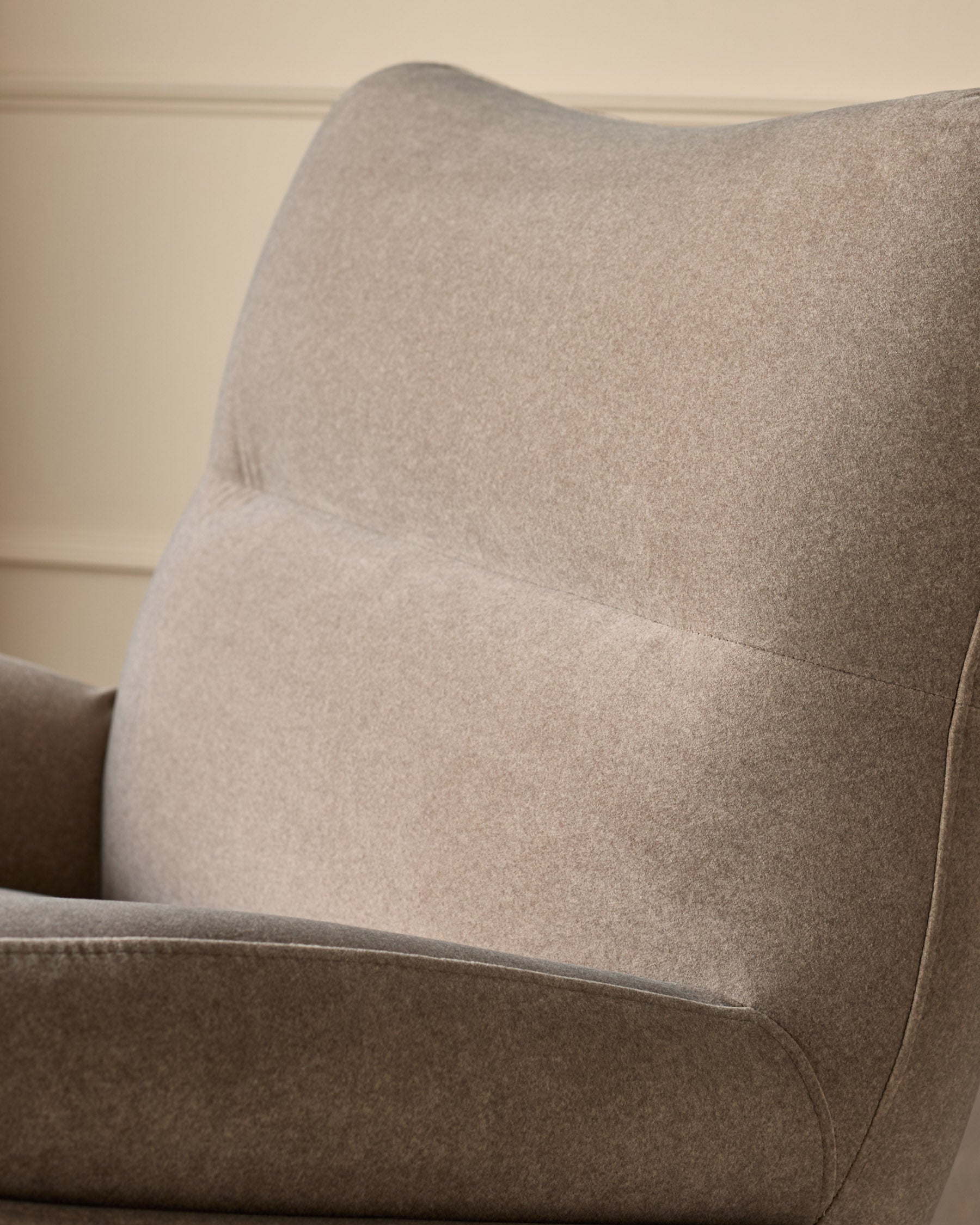 Piper accent chair in mocha fabric, shown from side angle highlighting curved backrest and cushioned seat detail.