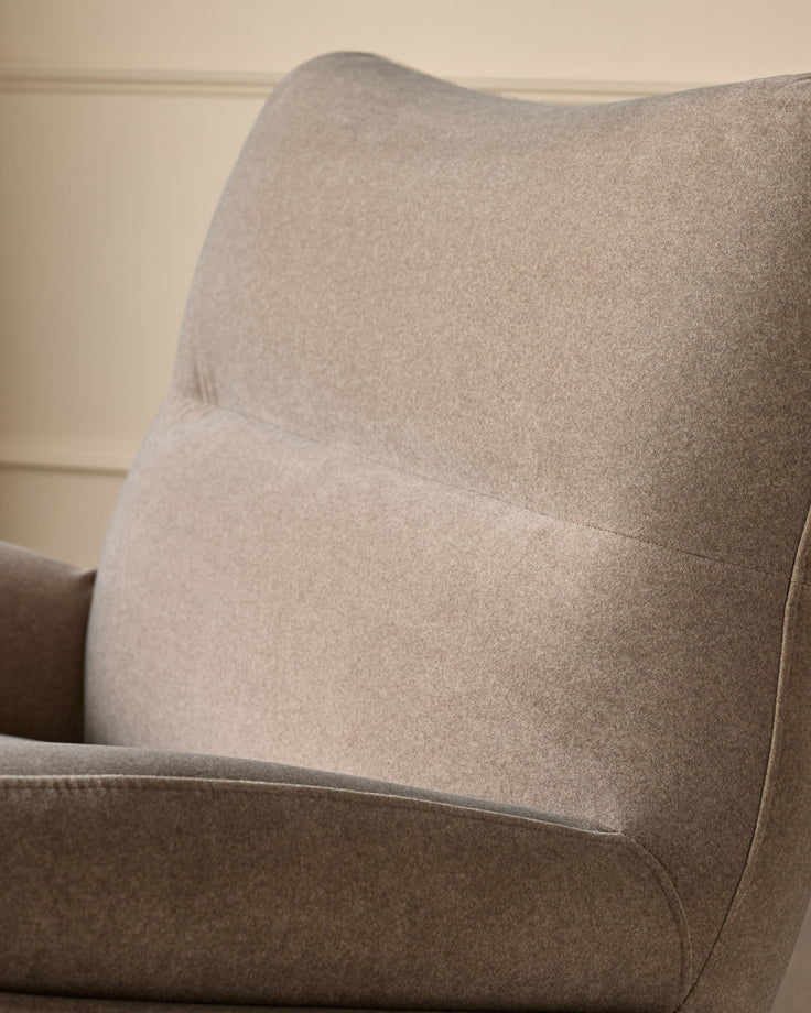 Piper accent chair in mocha fabric, shown from side angle highlighting curved backrest and cushioned seat detail.