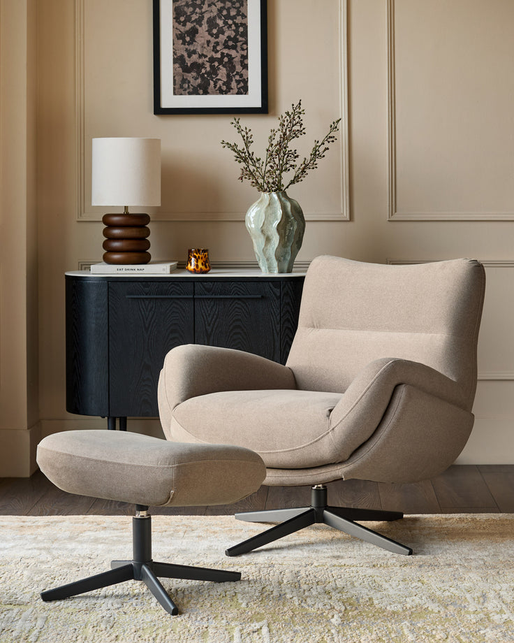 Mocha fabric accent chair with curved arms and matching footstool, black swivel base, in a styled living room setting.