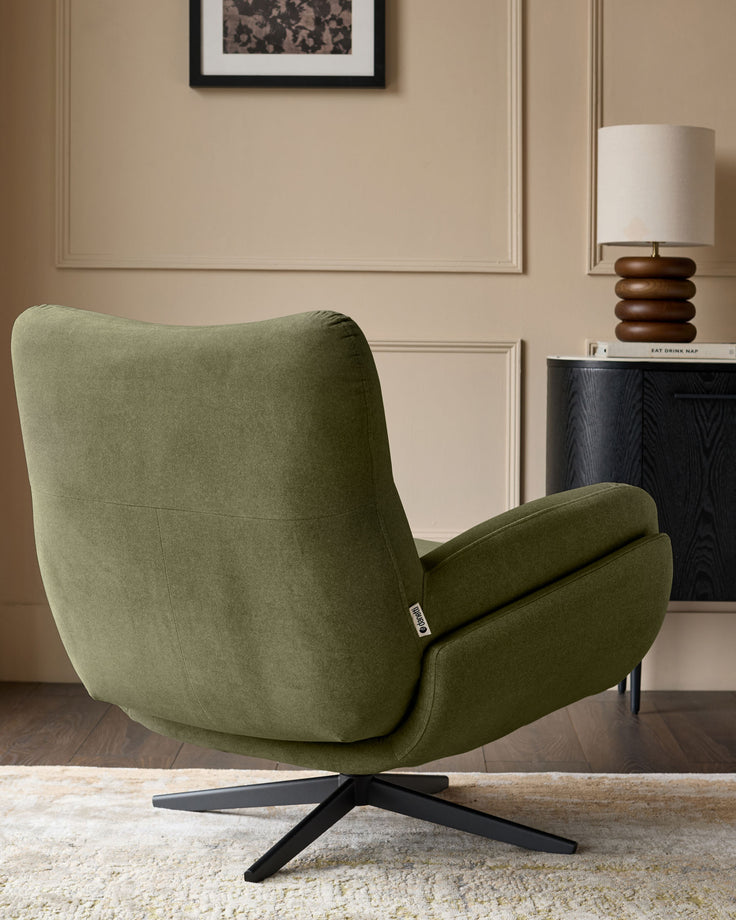 Olive green velvet accent chair with curved backrest and armrests, black star-shaped base, displayed in modern room setting.