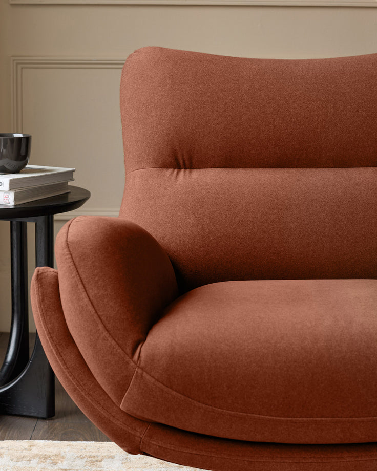 Toffee-red Piper accent chair with curved armrests and high back, shown from side angle with matching footstool.