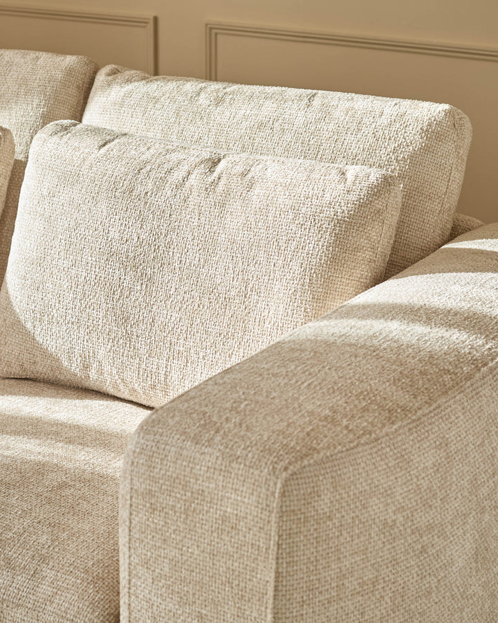 Quinn 2-seater sofa in natural fabric, showing close-up of cushioned armrest and seat with textured weave detail.