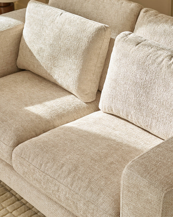 Quinn 2-seater sofa in natural fabric, showing close-up of seat cushions and back pillows with textured weave detail.