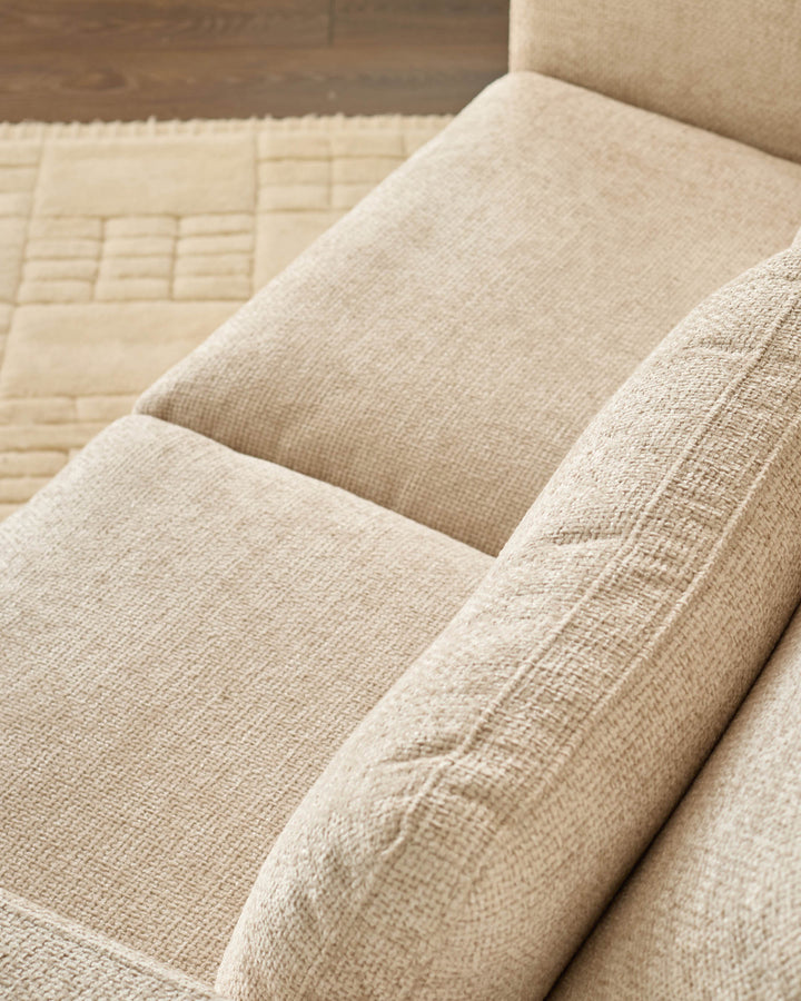 Quinn 2-seater sofa in natural fabric, close-up showing beige upholstery texture and quilted cushion detail.