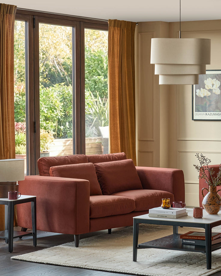 Quinn 2-seater sofa in toffee red fabric, shown in a living room setting with modern styling and neutral décor.