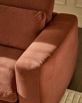 Quinn armchair in toffee red fabric, angled side view showing rolled arm and cushioned seat detail.